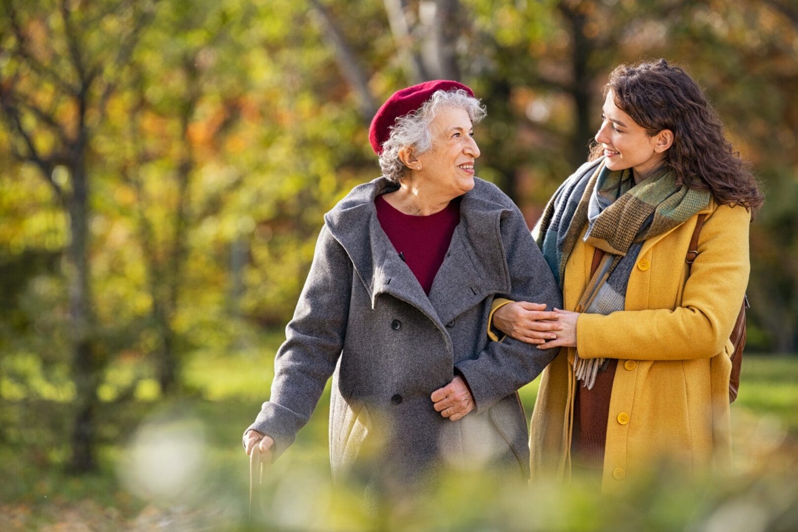 Young woman assisting elderly woman on walk