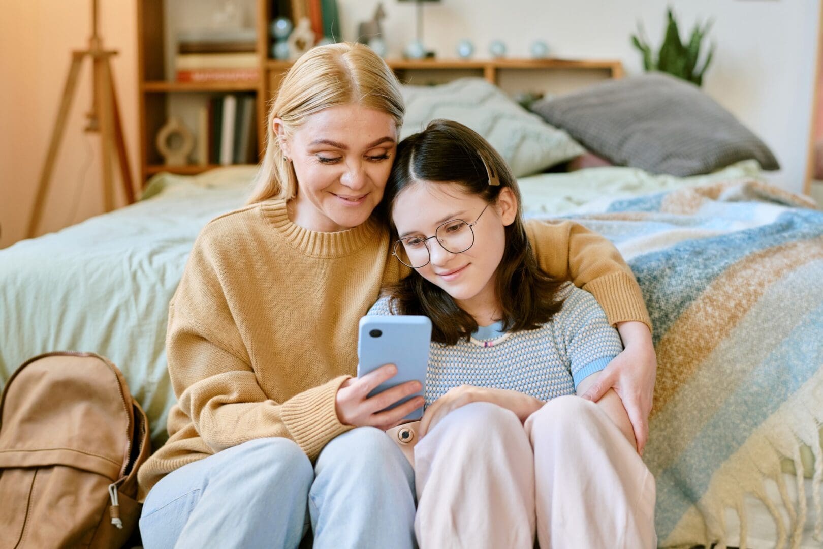Woman and girl bonding over phone
