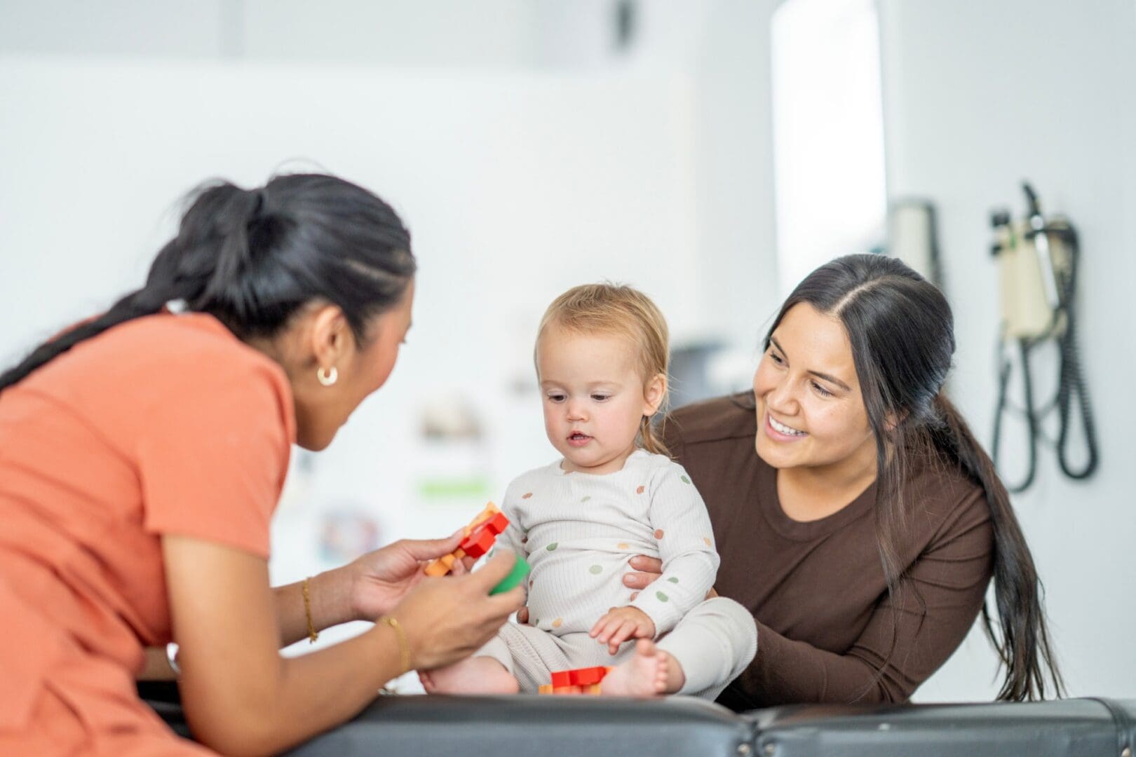 Baby playing with adults at a clinic