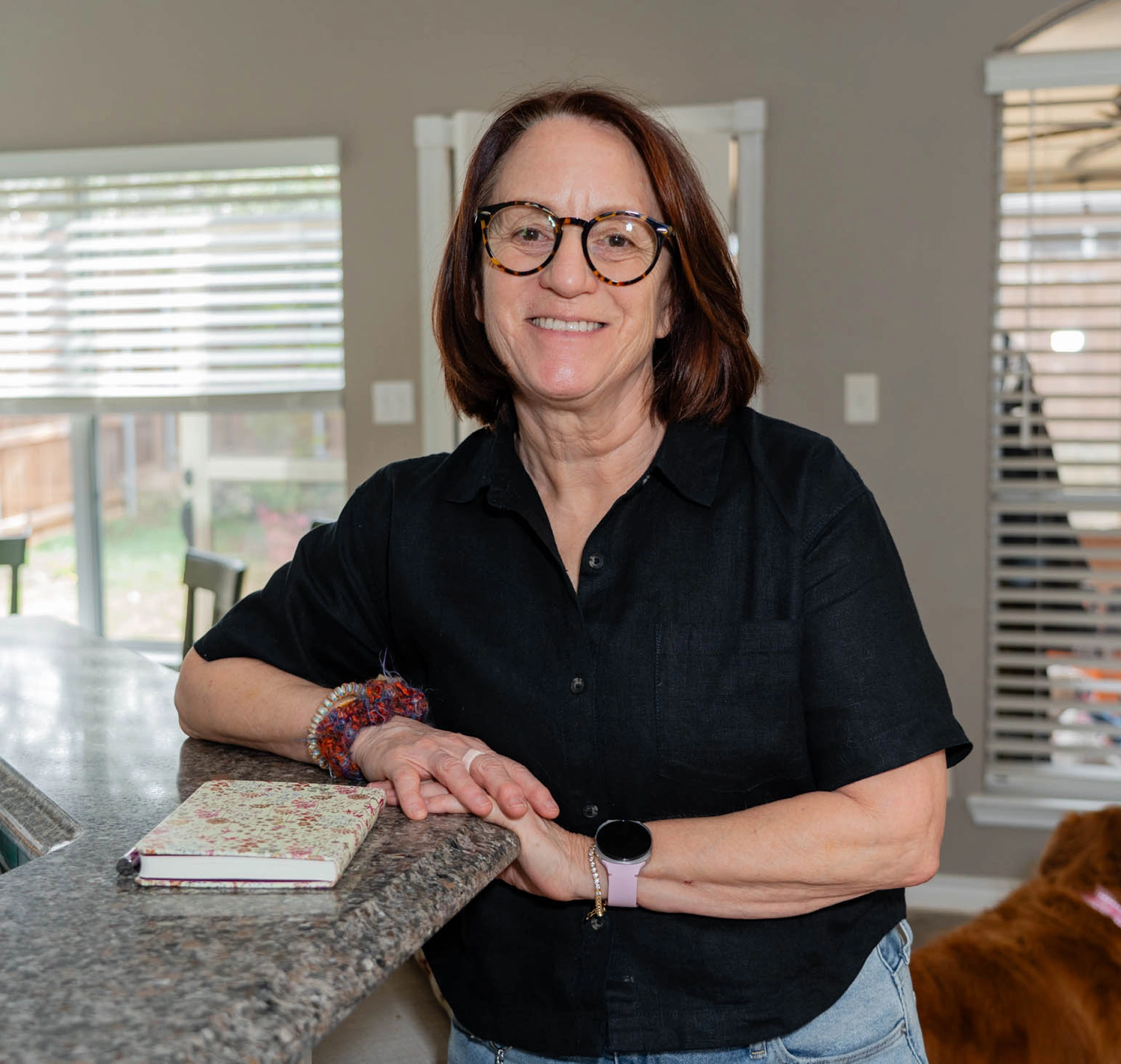 Smiling woman wearing round glasses at counter